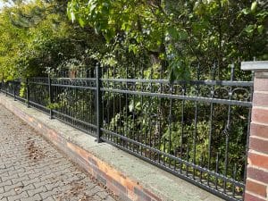 Schmiedeeiserner Zaun an einem sonnigen Tag.