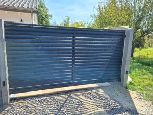 Modernes Schiebetor mit horizontalen Lamellen für Sichtschutz, hergestellt von KOMABUD.