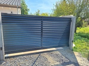 Modernes Metall-Schiebetor mit Lamellenfüllung, hergestellt von KOMABUD.