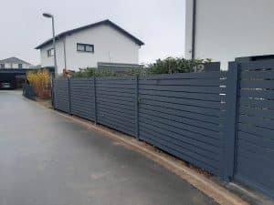 Moderner Metallzaun mit horizontalen Lamellen als Sichtschutz, hergestellt von KOMABUD.