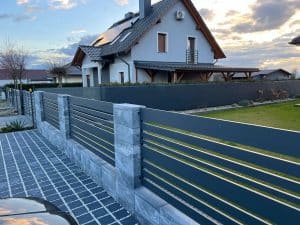 Moderner Aluminium-Metallzaun mit stilvollen horizontalen Lamellen und Betonsäulen, hergestellt von KOMABUD.