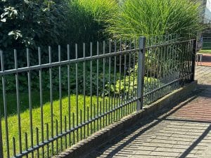 Minimalistischer schmiedeeiserner Gartenzaun mit vertikalen Stäben, hergestellt von KOMABUD.