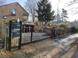 Schmiedeeiserner Zaun mit integriertem Briefkasten und moderner Eingangspforte, hergestellt von KOMABUD.