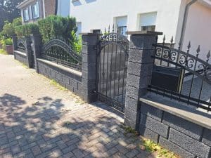 Schmiedeeiserner Zaun mit Wellenmuster und dekorativer Eingangspforte, hergestellt von KOMABUD.